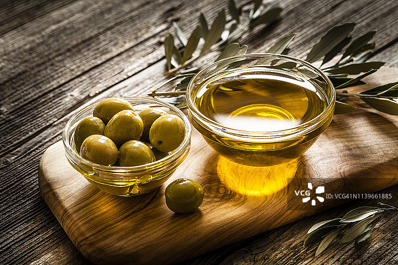 乡村木桌上的橄榄油和绿色橄榄图片素材