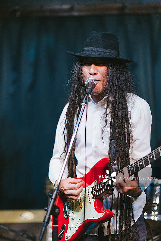 舞台上演奏吉他的雷鬼头男音乐人图片素材