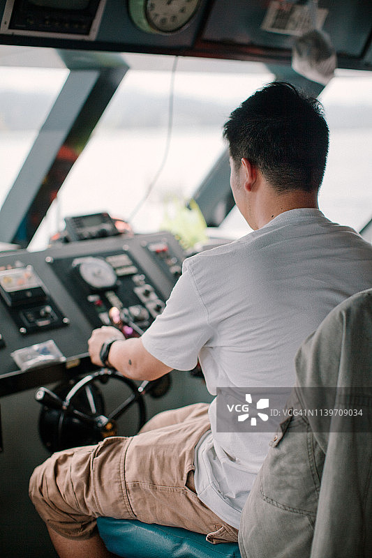 年轻的船长正在驾驶船图片素材