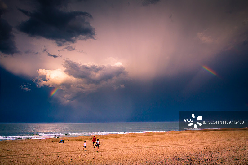 一家三口在海滩上看局部彩虹图片素材