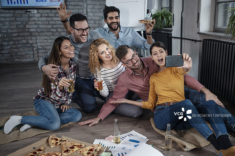 充满活力的创意商业团队欢呼雀跃，在办公室自拍图片素材