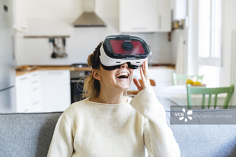 尝试VR眼镜的快乐年轻女人图片素材