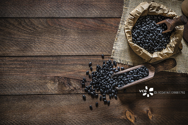 装满黑豆的乡村纸袋和木制勺子图片素材