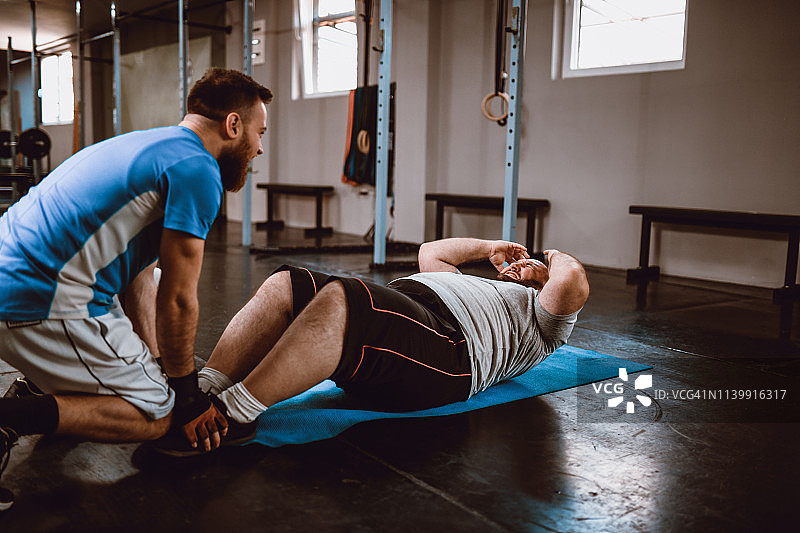 超重男性做腹部运动减肥图片素材
