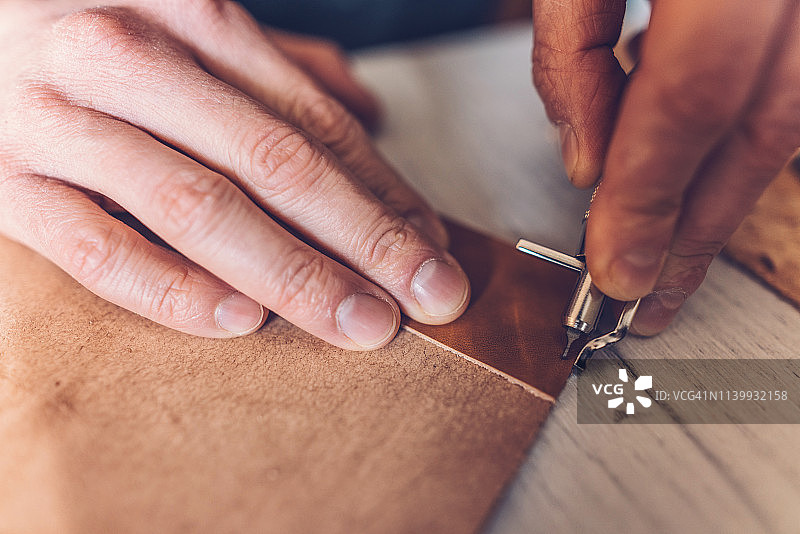 男人手工制作皮革书柜图片素材