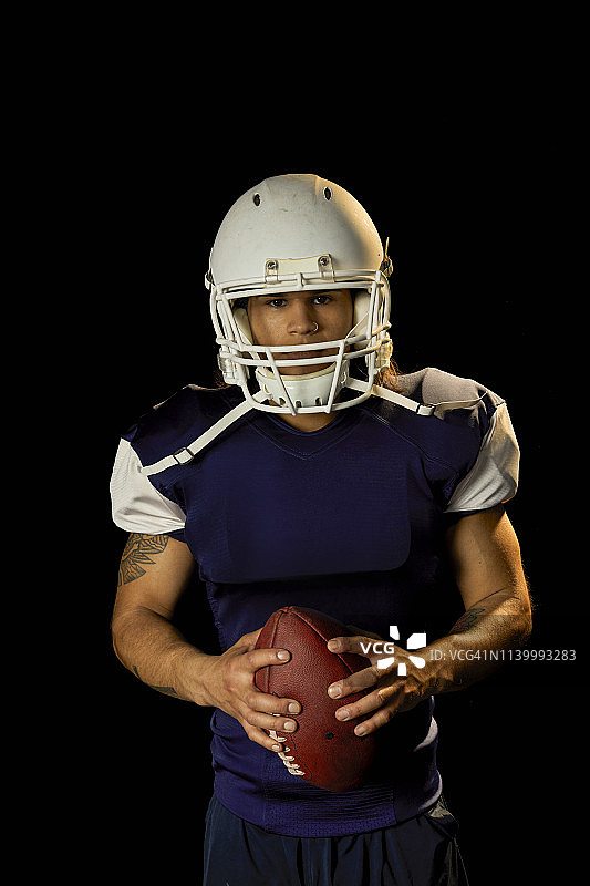 黑色背景下的足球运动员肖像图片素材