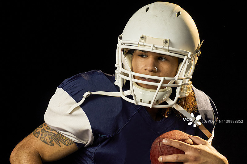 持橄榄球的四分卫肖像，黑色背景图片素材