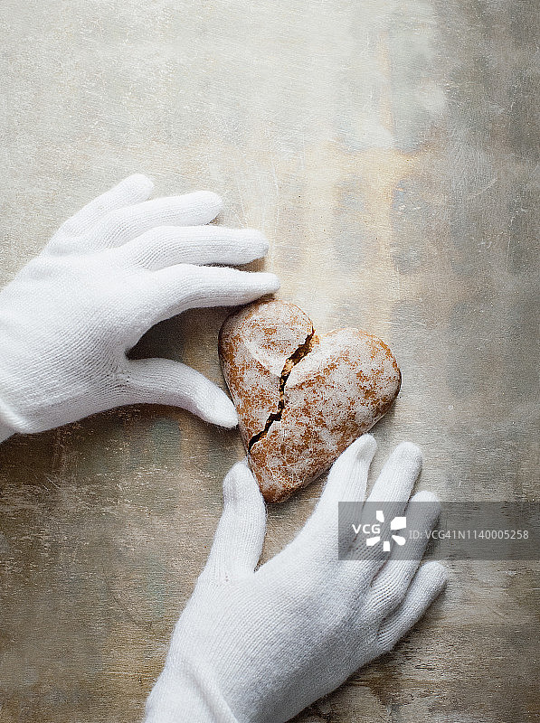 戴手套的手拿着心形姜饼图片素材