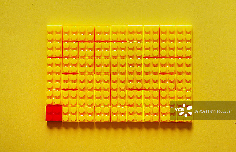 俯视拍摄的黄色玩具积木和红色积木，领导力概念图片素材