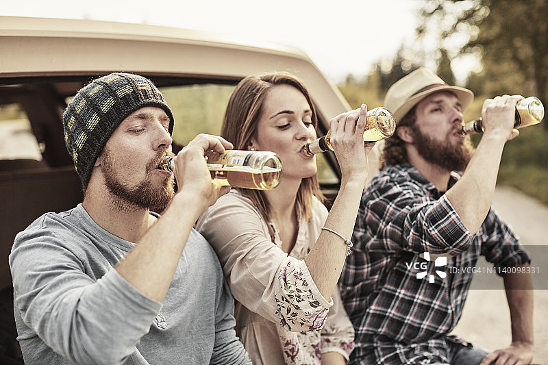 三人同时喝瓶装啤酒图片素材
