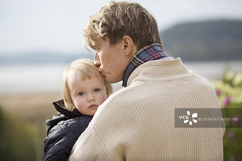 父亲在有机花园里亲吻儿子图片素材