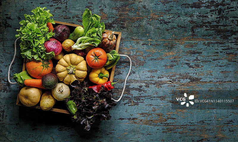 老式木制蔬菜托盘中色彩鲜艳的混合沙拉蔬菜图片素材