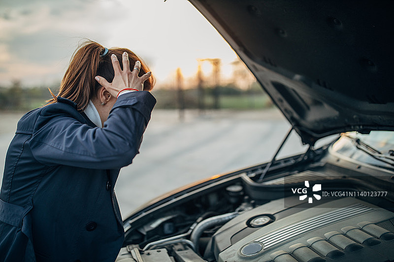 绝望的女人和抛锚的汽车图片素材
