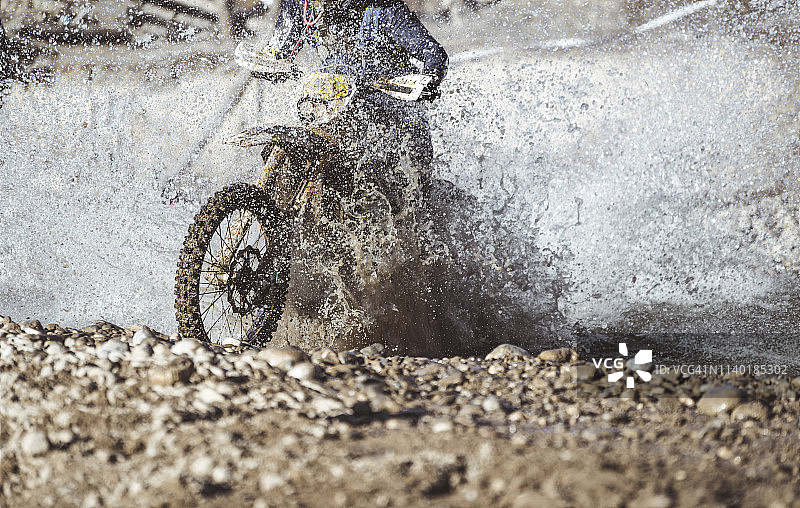 越野摩托车手涉水过河图片素材