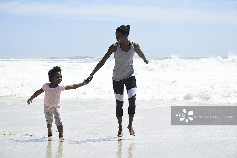 快乐的母女在海滩上玩耍图片素材