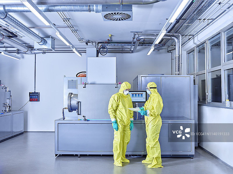在洁净室穿防护服的工业实验室工作的化学师图片素材