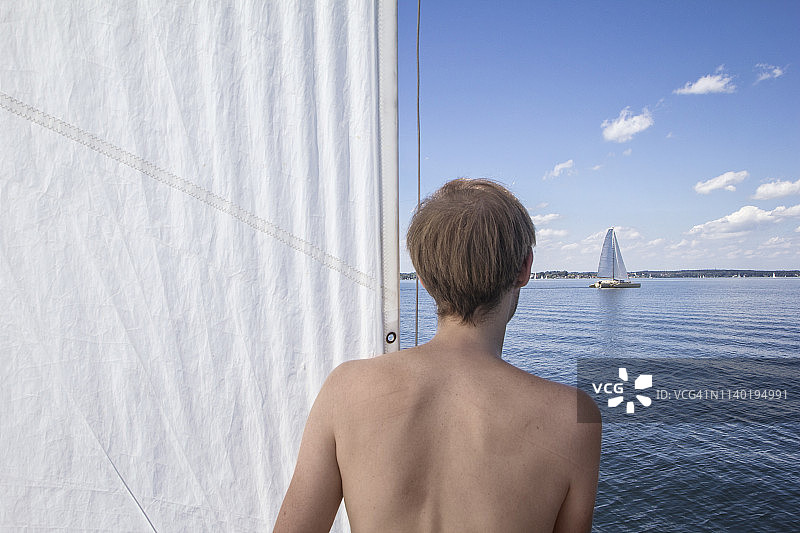 德国巴伐利亚州基姆湖，男子看着另一艘帆船图片素材