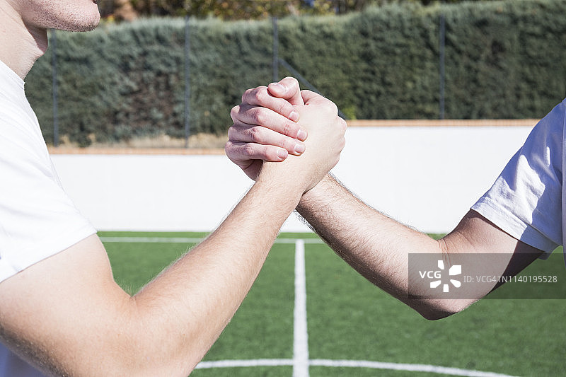 足球场上两名足球运动员握手的特写图片素材