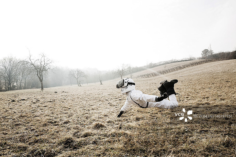 男孩穿着白色太空服，在草地上戴着VR眼镜摆姿势图片素材