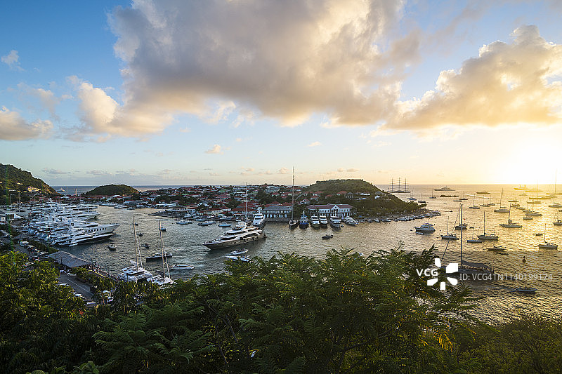 加勒比海圣巴泰勒米岛：古斯塔维亚港日落时分的豪华游艇图片素材