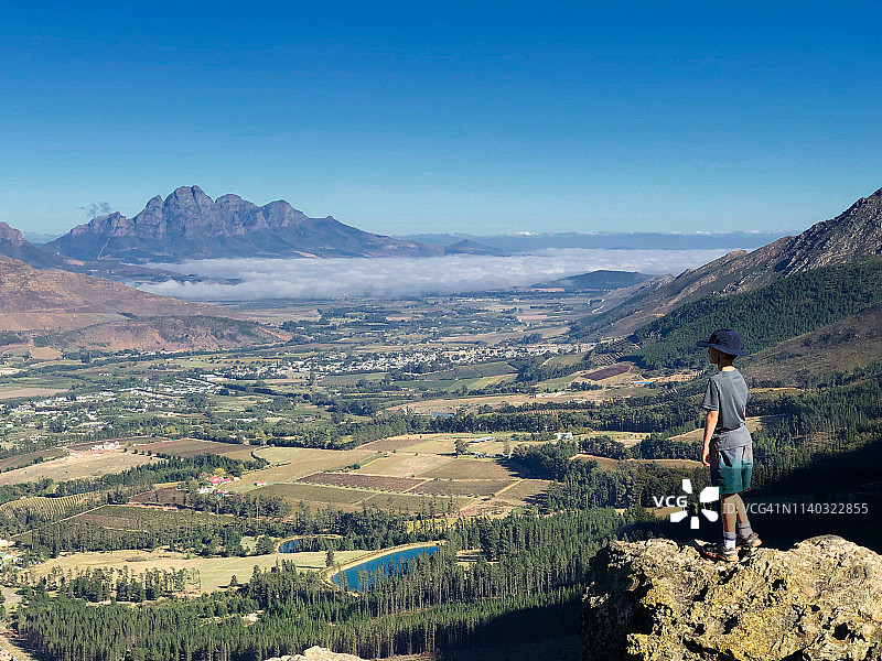 在山岩上俯瞰弗朗斯克胡克山谷的男孩图片素材