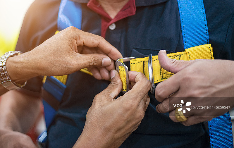 建筑工人在新建筑工地项目上使用安全带和安全绳图片素材