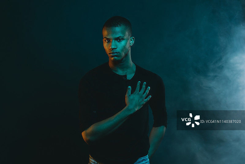 拥有彩色灯光的年轻男子肖像照图片素材