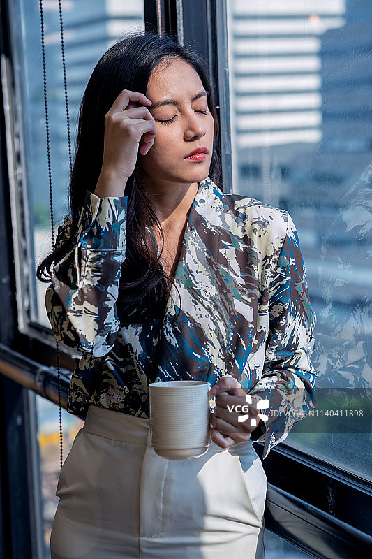 亚洲女商人因工作头痛感到压力图片素材