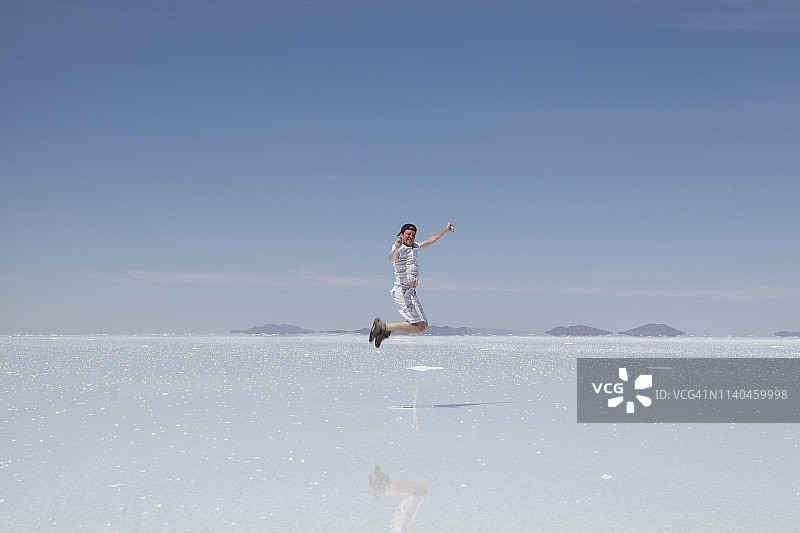 男人在盐滩上喜悦地跳跃图片素材