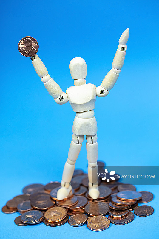 手持金钱的木制人体模型，财富的象征图片素材