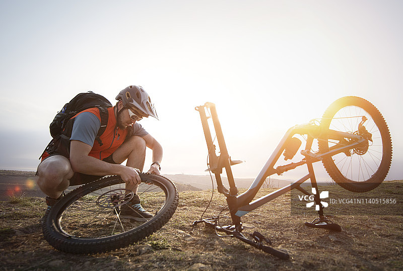 男子山地自行车手修理自行车图片素材