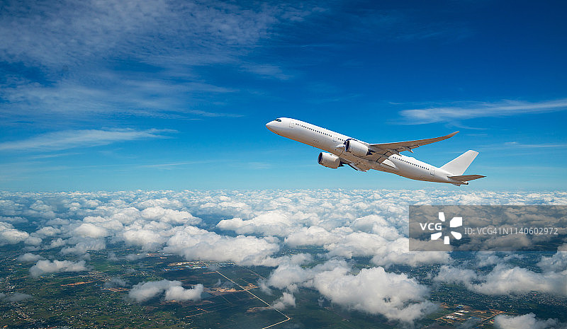 云层中飞行的商用飞机图片素材