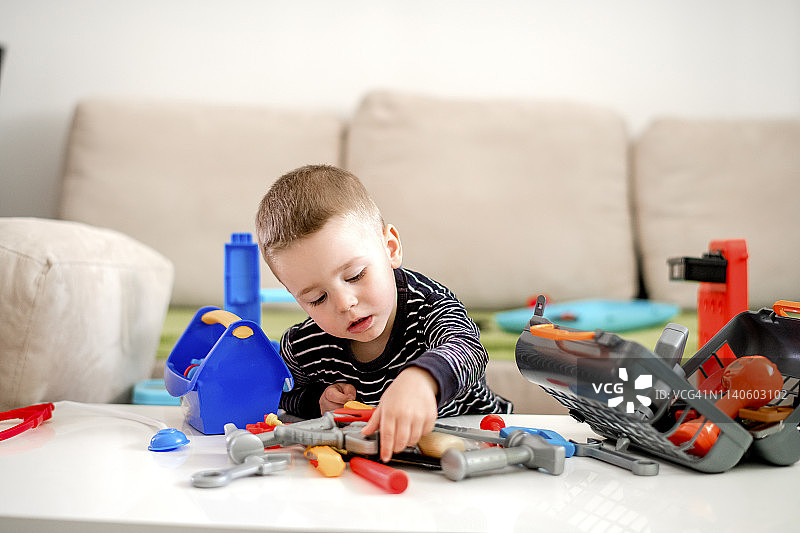 玩塑料工具的男孩图片素材