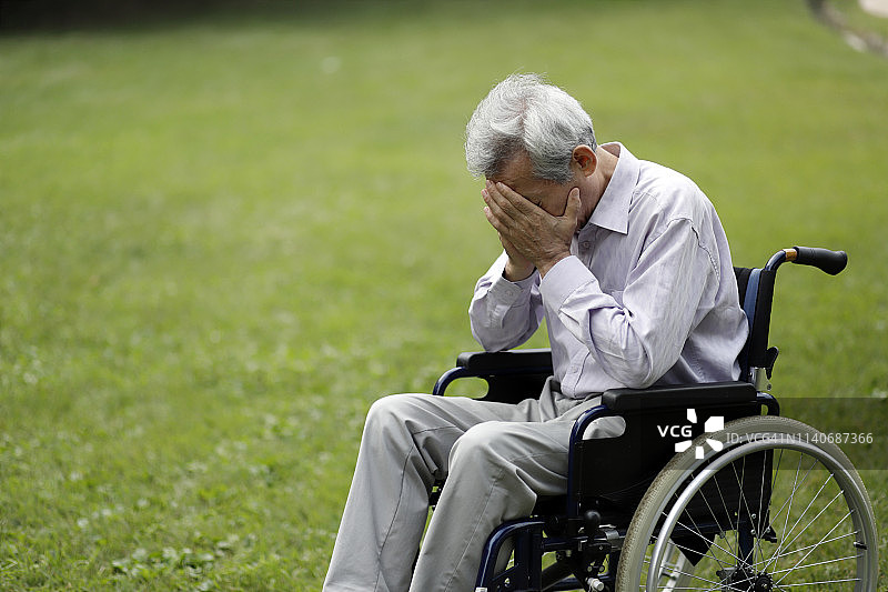 坐在轮椅上，头痛的年长男人图片素材