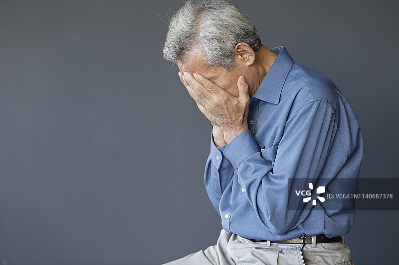 双手抱头的年长男人，悲伤、沮丧、绝望图片素材