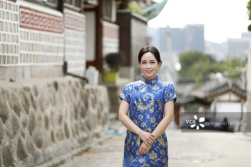 身穿旗袍的年轻女子在韩国首尔北村韩屋村旅行图片素材