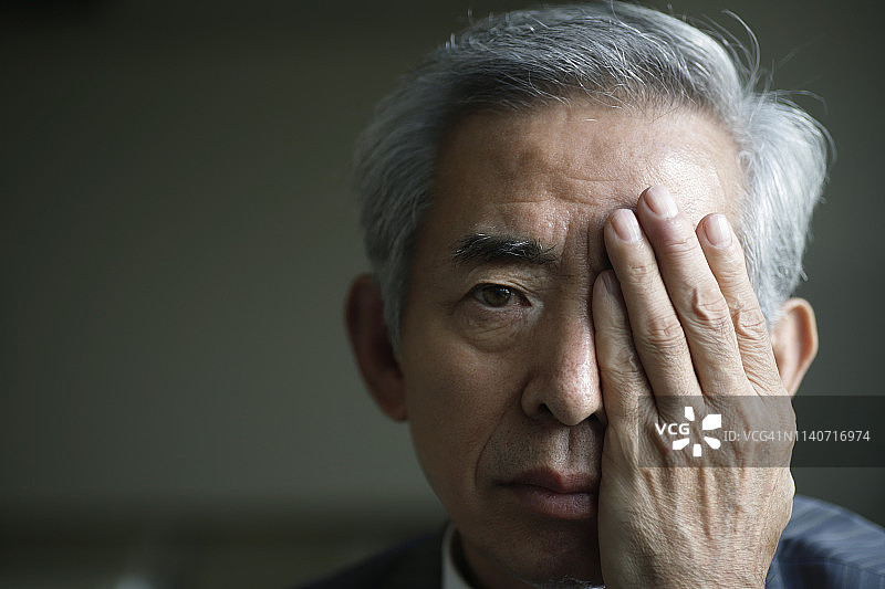 年长的男人用手遮住眼睛图片素材