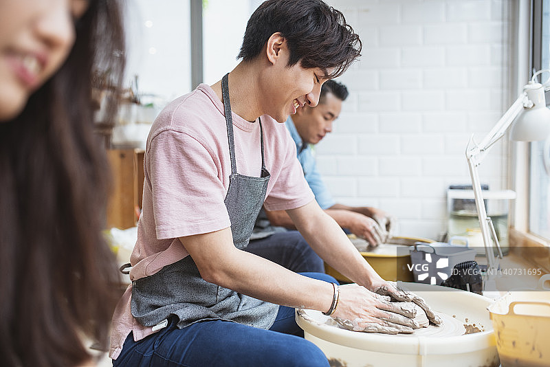 年轻男人在陶艺课上塑造黏土图片素材