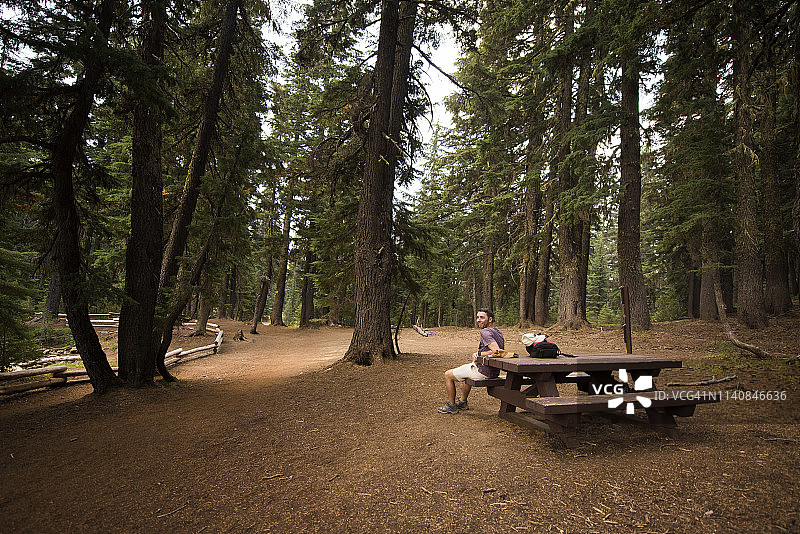 男人坐在俄勒冈州托德湖的木制湖边长椅上图片素材