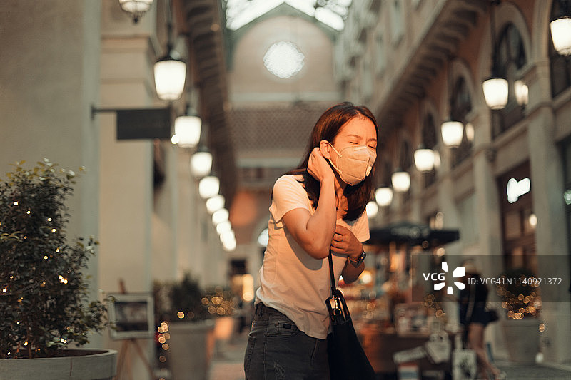 都市生活方式：佩戴防尘口罩的亚洲女孩图片素材