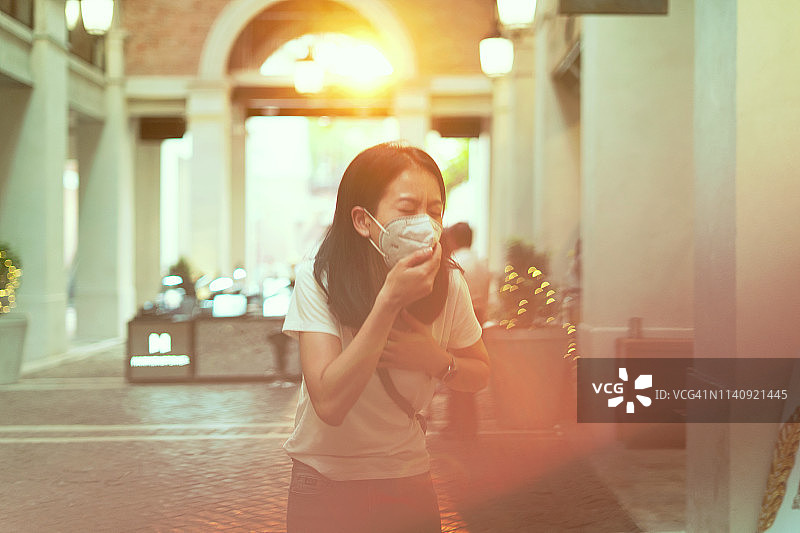 都市生活方式：佩戴防尘口罩的亚洲女孩图片素材