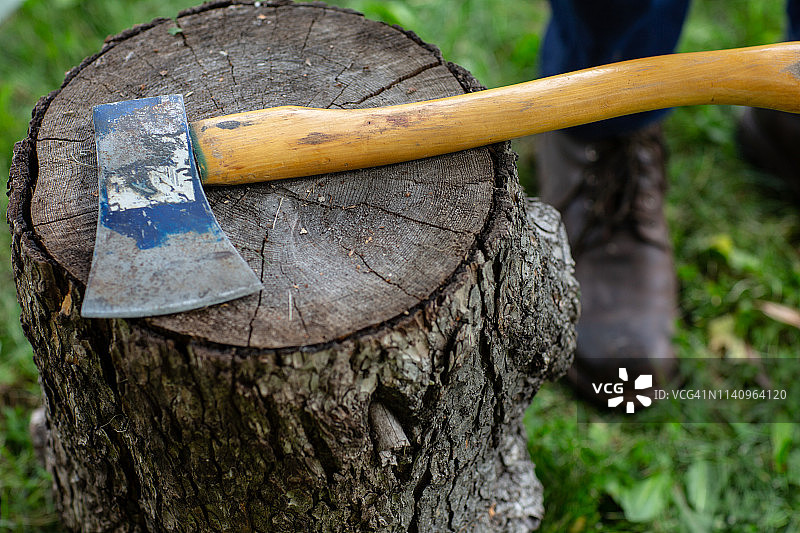 男人站在美国的一个木桩上的斧头旁边图片素材