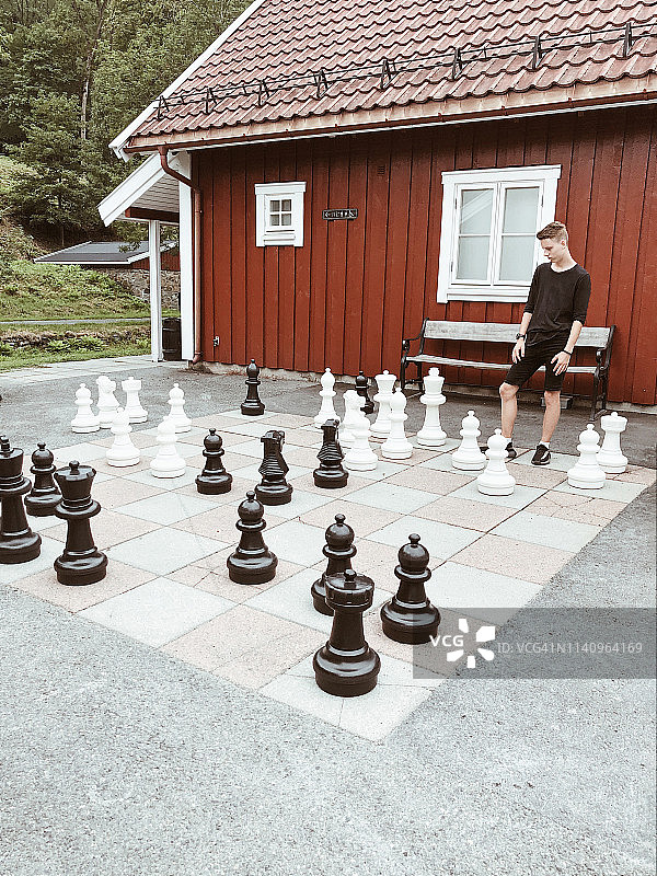 男孩在挪威阿克什胡斯郡拜鲁姆韦尔克玩巨型象棋图片素材