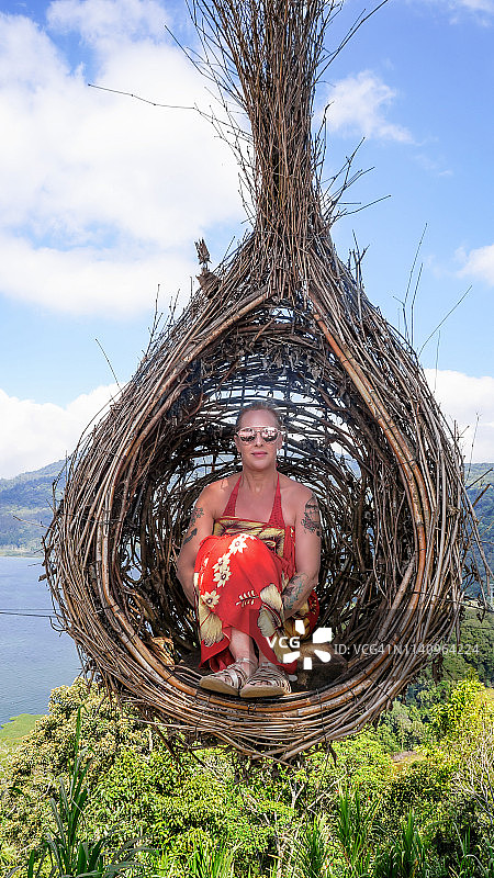 女人坐在印度尼西亚巴厘岛布扬和坦布林根双子湖旁的椅子上图片素材