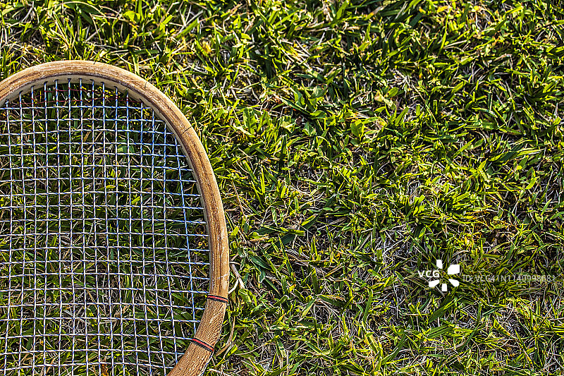 草地花园上的复古木制网球拍图片素材