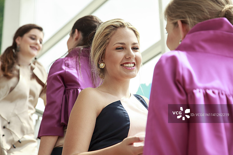 四位年轻女士穿着时尚连衣裙交谈图片素材