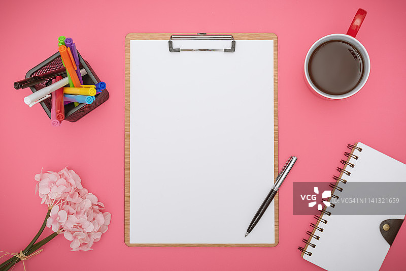粉色背景上的带办公用品的剪贴板图片素材
