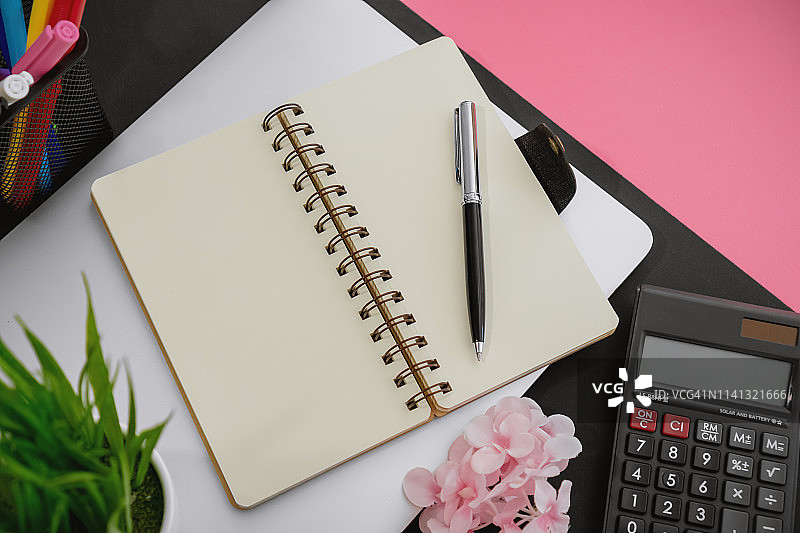 工作桌上的记事本、计算器和办公用品图片素材