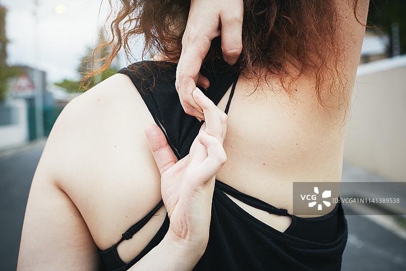 年轻女人双手背后，锻炼前伸展身体图片素材