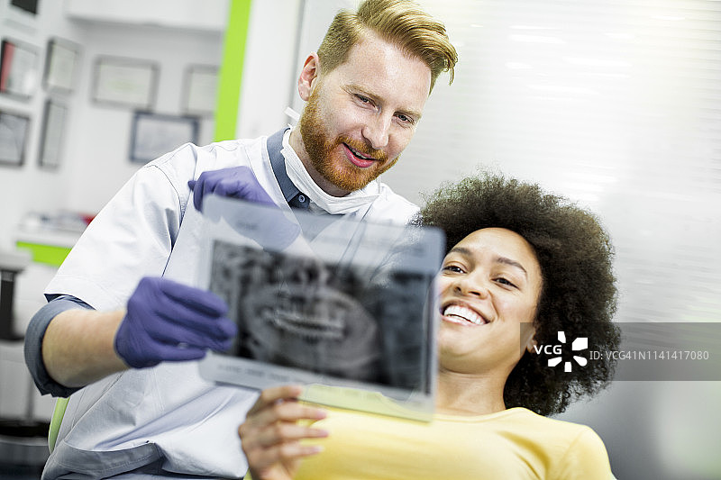 牙医向患者展示牙科全景X光片图片素材